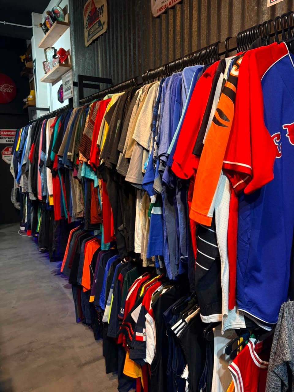 Perchero largo del local cargado de camisetas deportivas importadas